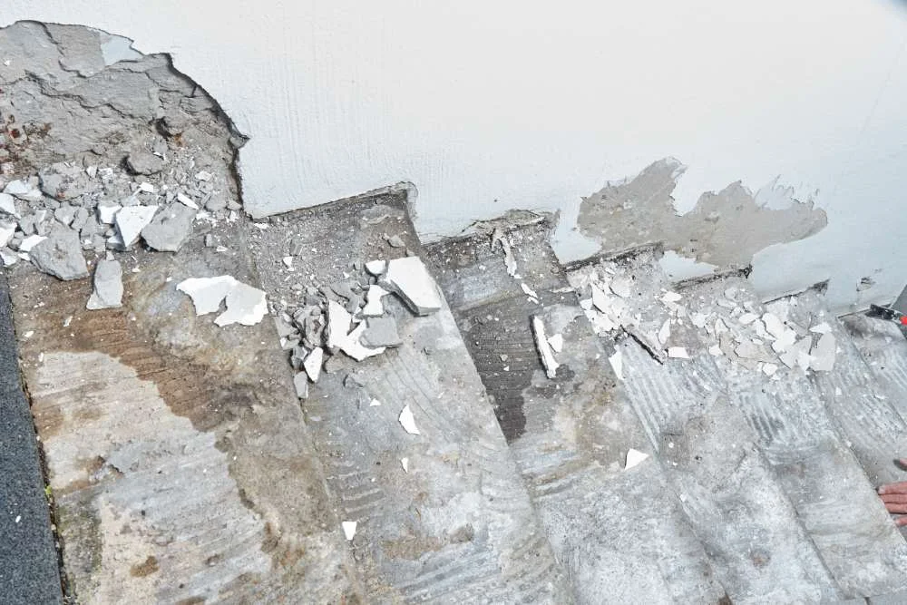 beschädigte Wand und Treppe im Kellereingang